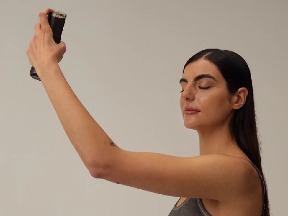 Frau sprüht Tanrevel-Selbstbräuner auf ihr Gesicht