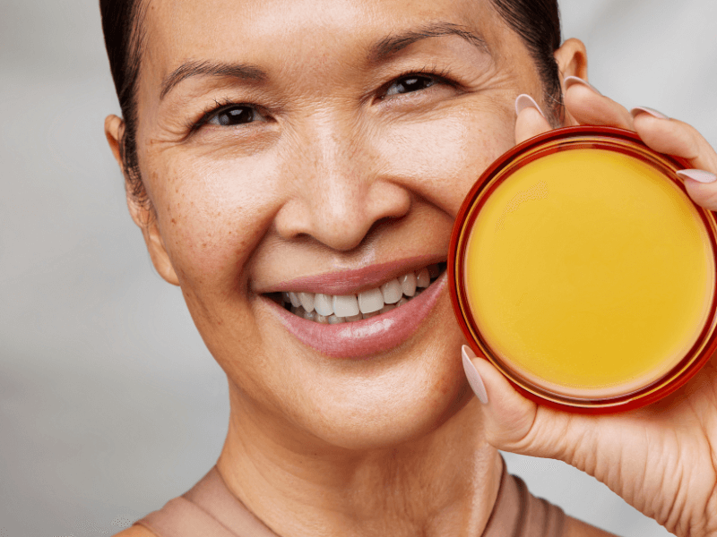 Asiatische Frau zeigt das Moisture Repair Balm von Danessa Myricks Beauty