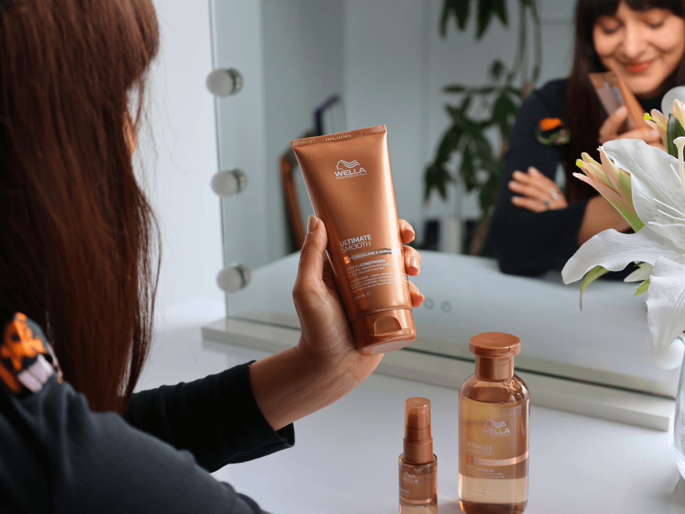 Hand hält das Ultimate Smooth Miracle Oil von Wella