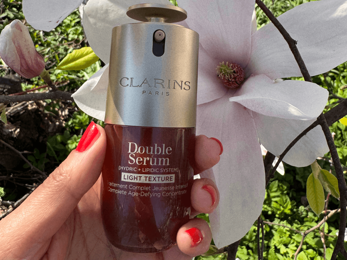 Frau hält das Double Serum Light von Clarins