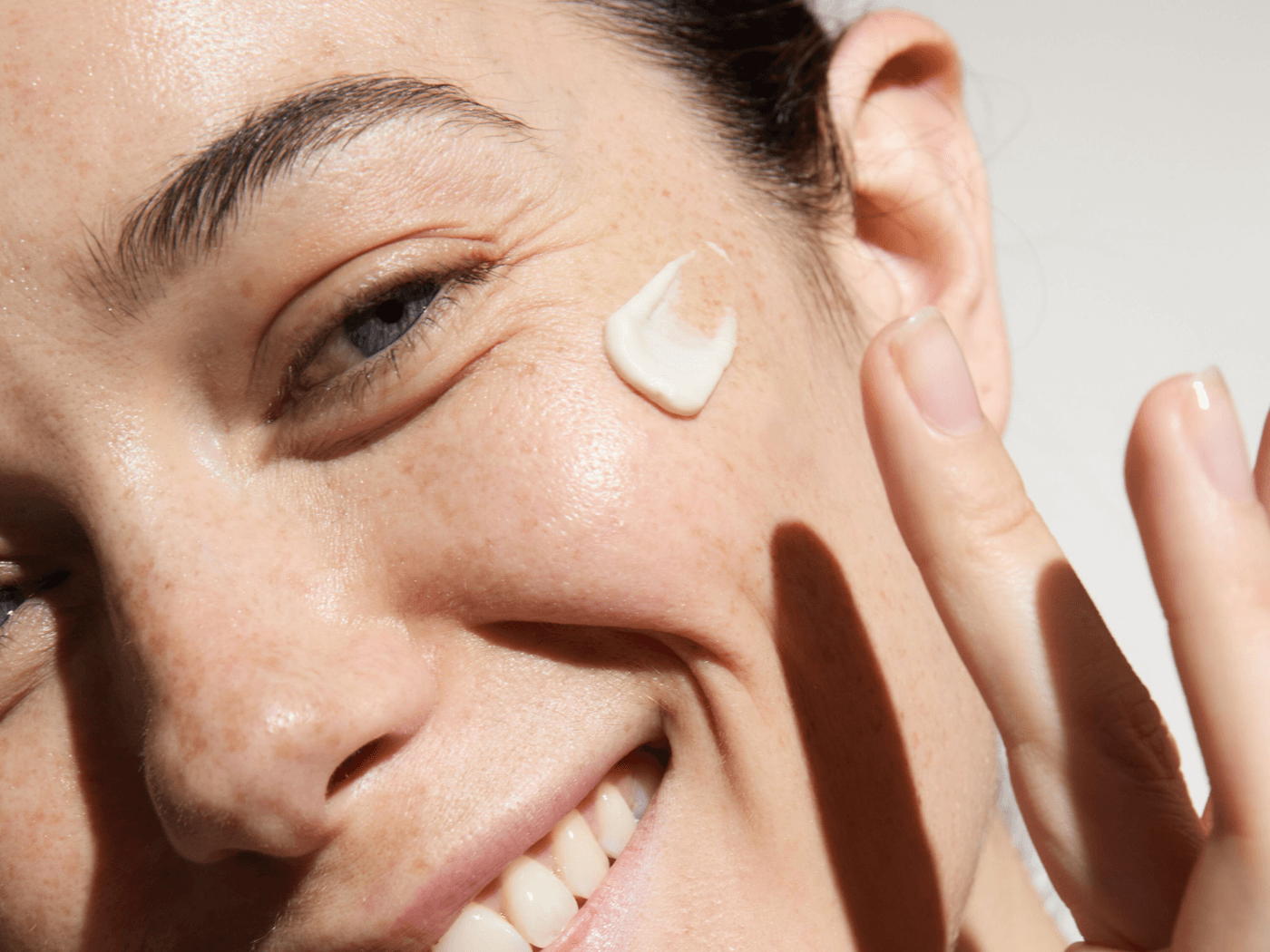 Frau mittleren Alters cremt ihr Gesicht mit einer Creme von Dr. Hauschka ein